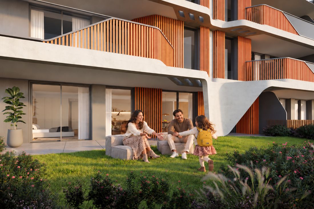 Família no relvado em frente aos apartamentos